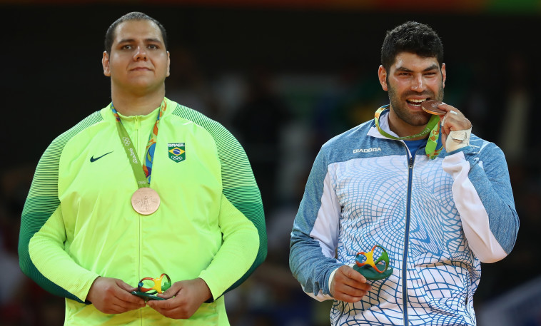 אורי ששון טועם את המדליה, צילום: Getty images