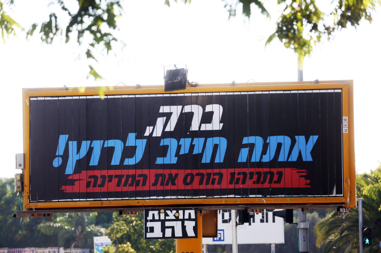 הרוב דווקא לא רוצים שהוא יחזור. שלט הקורא לאהוד ברק לחזור לפוליטיקה. צילום: אריאל בשור