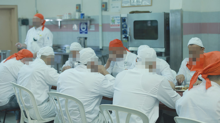 האסירים אוכלים את שבישלו בסיום היום. צילום: תמיר למפרט