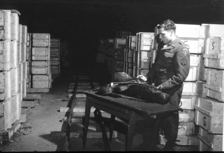 &quot;היהודים היו הקליינטים הכי טובים&quot;. חייל אמריקאי בוחן כינור שהיה שייך ליהודי והוחרם בידי הנאצים, לאחר שחרור המחנות, 1945. צילום: National Archives/gettyimages