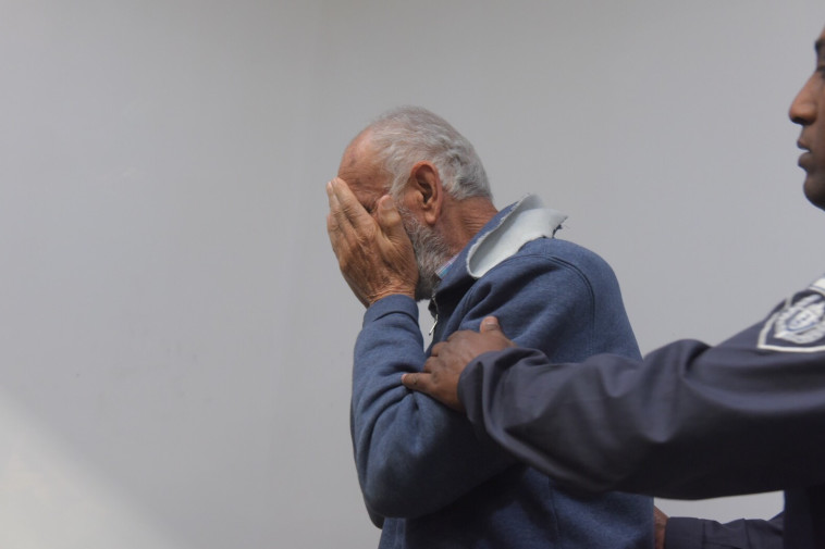 אשר פרג' מכסה את פניו בבית המשפט. צילום: אבשלום ששוני