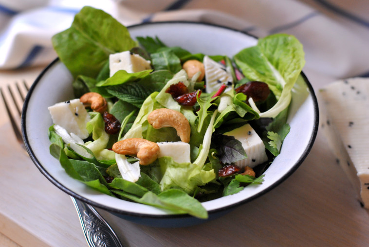 סלט עלים עם גבינה, קשיו וחמוציות.  מערבבים את כל החומרים, מלבד קוביות הגבינה, בקערה. צילום: פסקל פרץ רובין