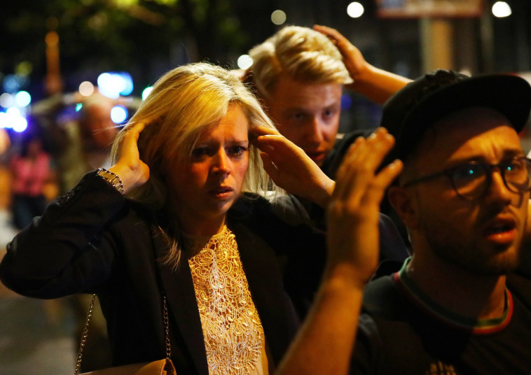 תושבים בריטים עם ידיהם על ראשיהם מחוץ לאזור המתקפה. צילום: רויטרס