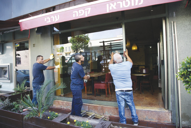 שיפוץ של חנות לאחר המהומות ביפו. צילום: אלוני מור