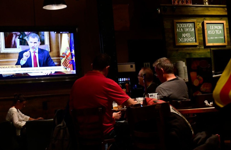 אזרחי ספרד צופים בנאום המלך פליפה. צילום: AFP