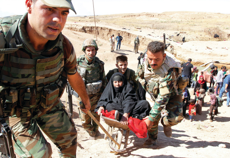 חיילי פשמרגה בכירכוכ מעבירים פליטים כורדים למחנות עקורים. צילום: רויטרס