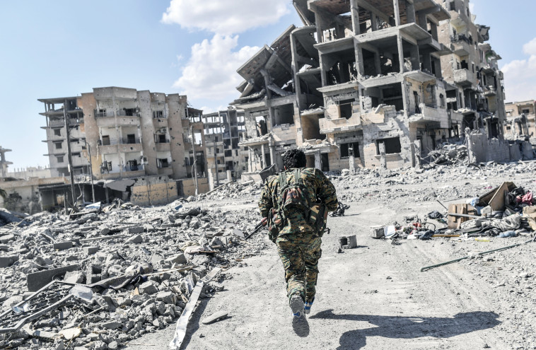 חייל של צבא סוריה החופשי רץ לתפוס מחסה בעיר א־רקה