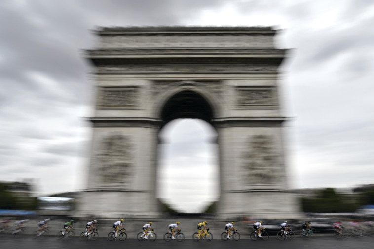 רוכב האופניים כריסטופר פרום, במדים הצהובים, חולף על פני שער הניצחון בטור דה פראנס