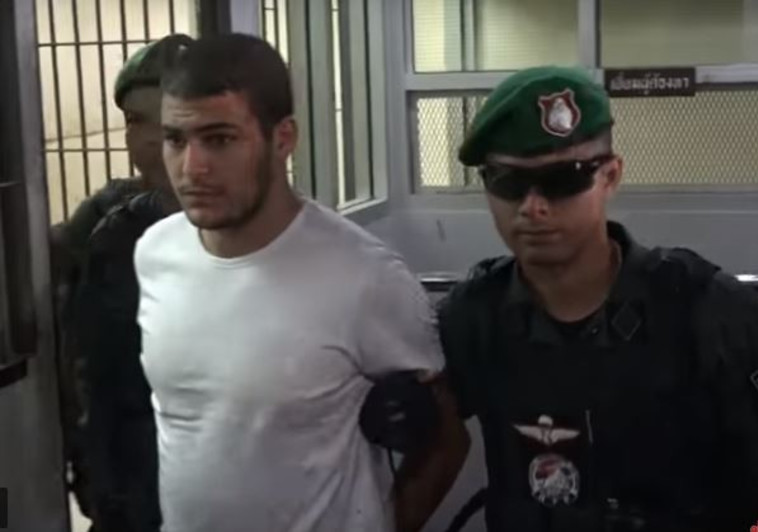 אחד החשודים מובא למעצר בתאילנד. צילום מסך מתוך יוטיוב