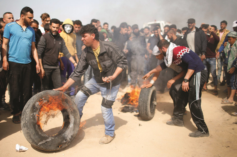 פלסטינים מבעירים צמיגים בהפגנה בגבול רצועת עזה. צילום: רויטרס 