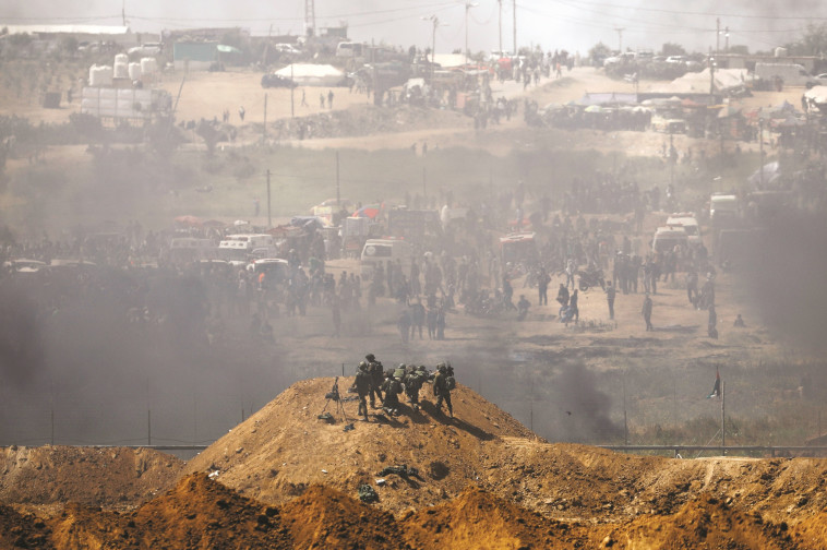 חיילי צה&quot;ל מול מפגינים פלסטינים בגדר רצועת עזה. צילום: רויטרס