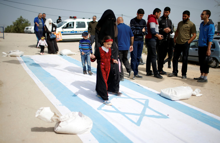 דורכים על דגל ישראל ברצועת עזה. צילום: רויטרס 