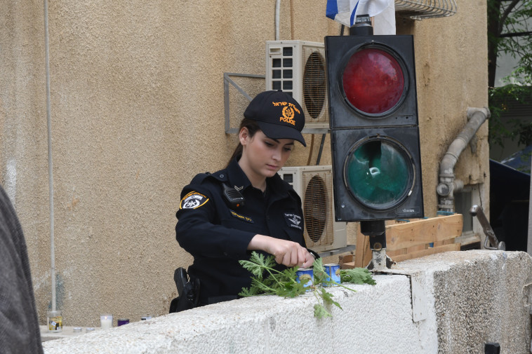 שוטרת מדליקה נהר זיכרון מחוץ למכינה. צילום: אבשלום ששוני