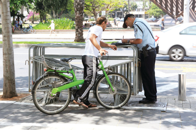פקח רושם דוח לרוכב אופניים. צילום: אבשלום ששוני