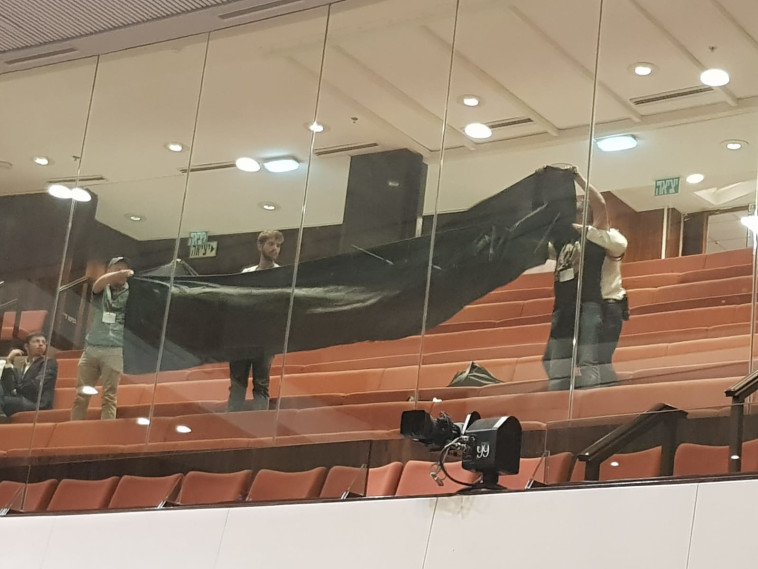 פעילי שלום עכשיו מניפים דגל שחור במהלך הדיון על חוק הלאום