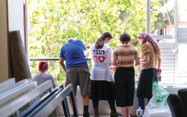 מתנדבים מסדרים דירה שנפגעה מטיל איראני  (צילום: דור פוזאלו)