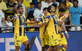 שחקני מכבי תל אביב חוגגים עם דור פרץ (צילום: ברני ארדוב)