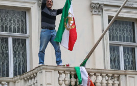 הסרת דגל איראן מבניין השגרירות בלונדון בידי מפגין (צילום: צילום מסך bbc)