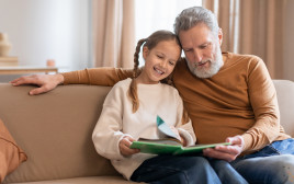 סבא ונכדה קוראים ספר (צילום: Shutterstock)