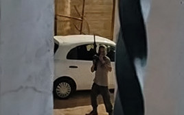 מתנחל עם נשק שלוף בכפר אל מוע'ייר (צילום: צילום מסך,שימוש לפי סעיף 27 א')