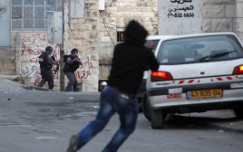 יידוי אבנים על שוטרי מג"ב בידי צעיר פלסטיני (צילום: פלאש 90)