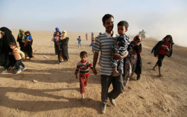 אזרחים חוזרים לכפרים ששוחררו באזור מוסול (צילום: רויטרס)