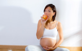 אישה בהיריון אוכלת (צילום: אינג אימג')