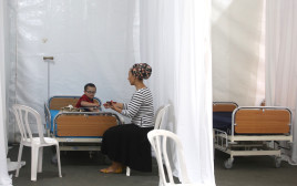 ילד חולה ואמו בבית חולים שדה שהוקם בגן סאקר (צילום: מרק ישראל סלם)