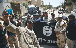 לוחמי הצבא העיראקי עם דגל דאעש, ארכיון (צילום: רויטרס)