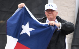טראמפ מנופף בדגל טקסס (צילום: AFP)