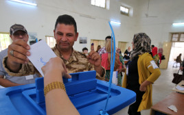 חייל כורדי מצביע במשאל העם (צילום: AFP)