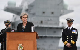 תרזה מיי על רקע נושאת המטוסים "המלכה אליזבת" (צילום: AFP)