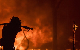 לוחם אש נלחם בשריפה (צילום: AFP)