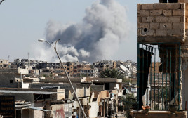 עשן עולה לאחר הפצצה בעיר הסורית א-ראקה (צילום: רויטרס)