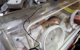 תינוק סורי שהועבר לניתוח חירום בביה"ח שיבא (צילום: חברת גשר אווירי)