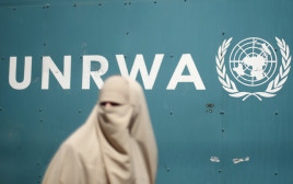 אישה פלסטינית ליד מטה אונר"א בעזה (צילום: רויטרס)