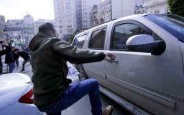 מפגין פלסטיני בועט ברכב אמריקאי בבית לחם (צילום: AFP)