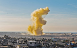 עשן מיתמר מעל רפיח, בצד המצרי של הגבול (צילום: AFP)