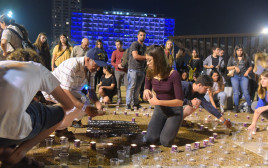 צעירים בכיכר רבין מדליקים נרות לזכר ההרוגים באסון הערבה (צילום: אבשלום ששוני)