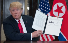 דונלד טראמפ עם ההסכם שנחתם עם קוריאה הצפונית (צילום: AFP)