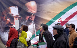 איראנים מול כרזות של חומייני וחמנאי בטהרן (צילום: רויטרס)