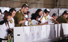 מתנדבים אורזים חבילות מזון (צילום: עמותת מגדל אור)