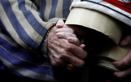ניצול השואה אדוארד מוסברג אוחז את ידה של נכדתו במצעד החיים (צילום: רויטרס)