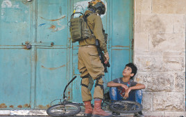 חייל צה"ל ונער פלסטיני (צילום: רויטרס)