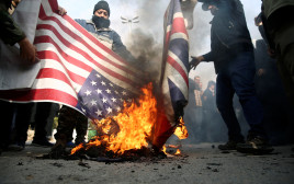 מפגינים באיראן שורפים דגל ארצות הברית (צילום: רויטרס)