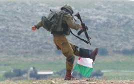 חייל צה"ל בועט בדגל פלסטיני (צילום: רויטרס)
