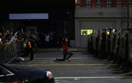 מפגין בארה"ב כורע ברך מול שוטרים (צילום: רויטרס)