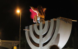 מפגינה מתערטלת על סמל המנורה בכנסת (צילום: אם תרצו)