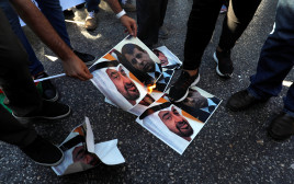פלסטינים שורפים את תמונותיהם של בן זאיד ודחלאן במחאה על ההסכם בין ישראל לאיחוד האמירויות (צילום: REUTERS/Mohamad Torokman)