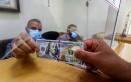 דולר עובר מיד ליד (צילום: עבד רחים כתיב, פלאש 90)